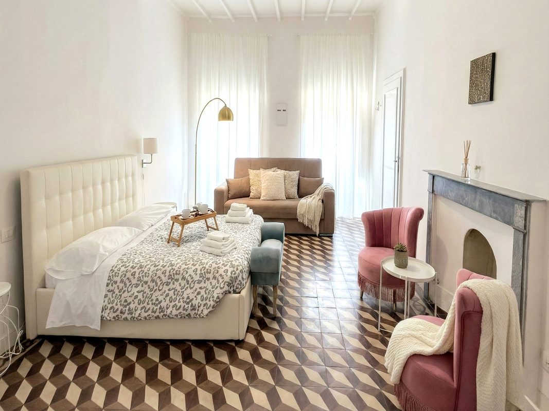 alloggiare-in-toscana-camera-loft-arezzo Camera del Loft 2 ad Arezzo con letto matrimoniale, divano e camino