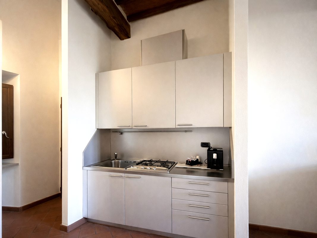 cucina-camera-michelangelo-toscana Cucina attrezzata della camera Michelangelo con piano cottura, lavello e macchina da caffè