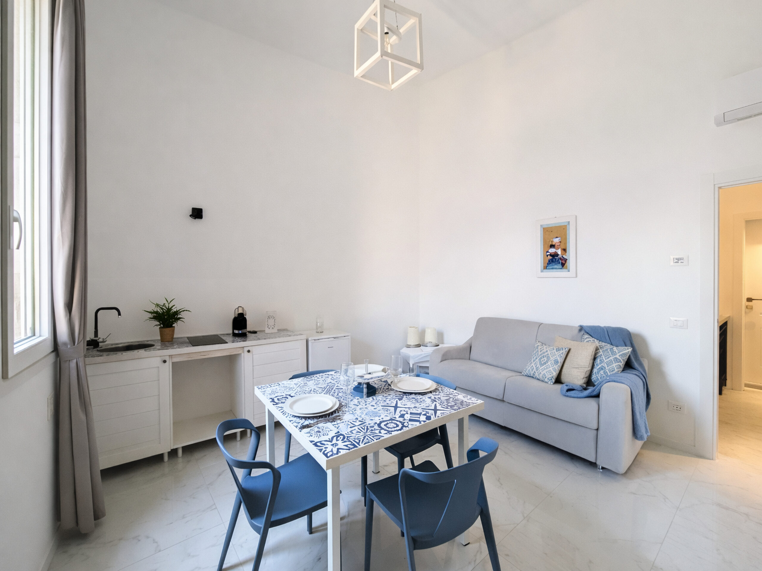 SUITE-VIAREGGIO Soggiorno della suite a Viareggio con cucina, tavolo da pranzo e divano