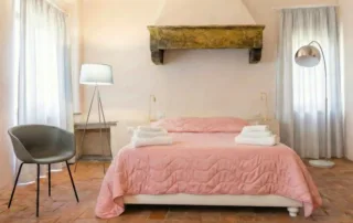 Camera da letto king size con letto rosa e travi in legno - Suite King Allegra Toscana Arezzo