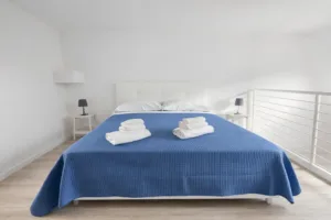 suite Duplex Allegra Viareggio su due livelli con scala interna, camera matrimoniale al piano superiore e soggiorno con angolo cottura al piano terra"