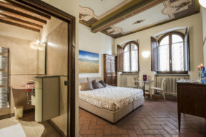 alt="Suite Deluxe Corte del Re centro storico Arezzo, camera spacious con letto king size, bagno in marmo e affreschi originali del palazzo medievale"