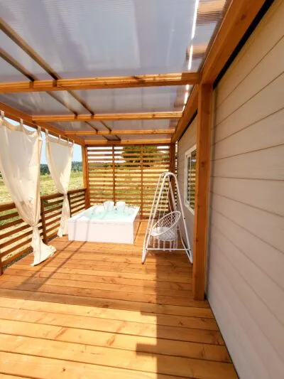 bungalow-rosmarino-terrazza-coperta-altalena.png Camera matrimoniale con travi a vista nel Bungalow Rosmarino Antria Arezzo