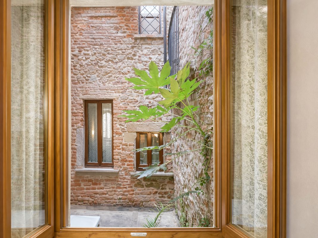 affaccio-cortile-storico-arezzo Affaccio dalla camera su un cortile interno con antiche pareti in pietra e mattoni