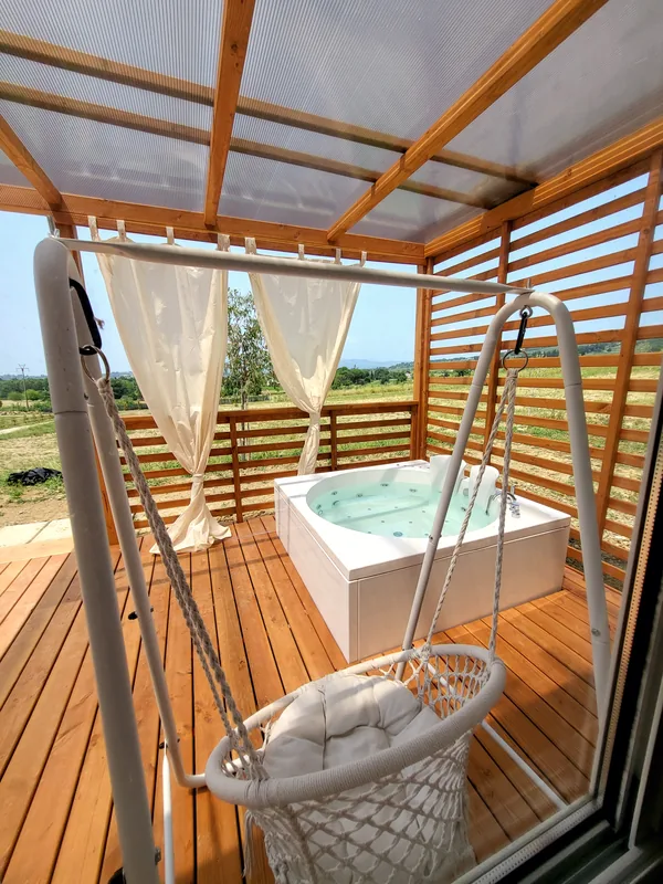 veranda-bungalow-mirto-con-jacuzzi Veranda privata del bungalow Mirto con vasca idromassaggio e poltrona sospesa
