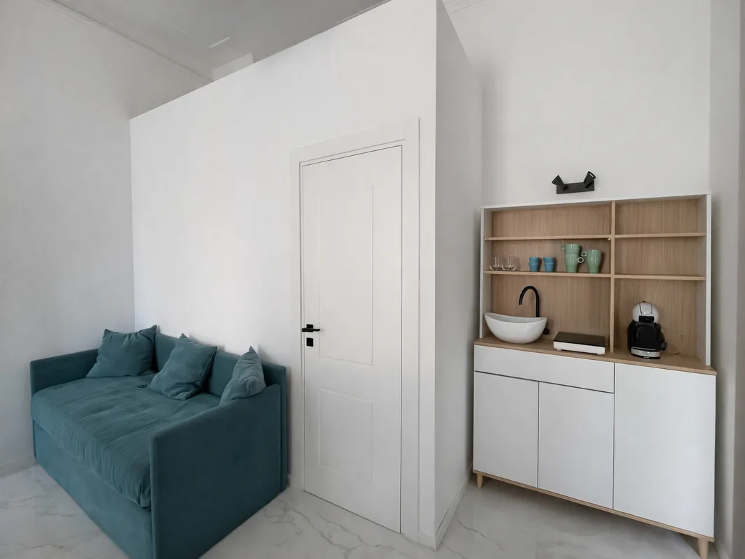zona-living-angolo-caffe-viareggio.webp Zona relax della suite a Viareggio con divano e angolo caffè attrezzato