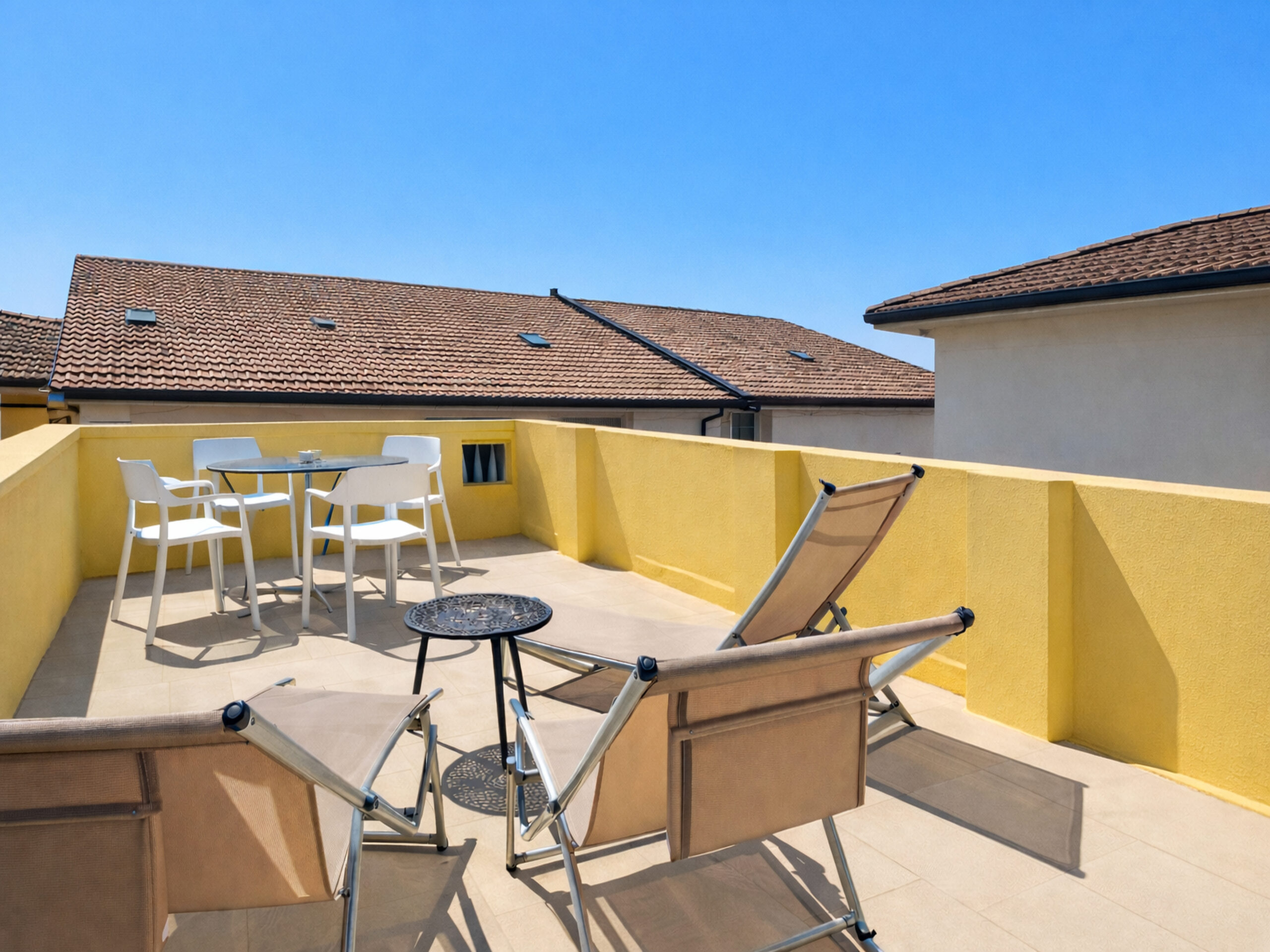 APPARTAMENTO-CON-TERRAZZA-VIAREGGIO Terrazza privata della suite a Viareggio con tavolo, sedie e lettini prendisole