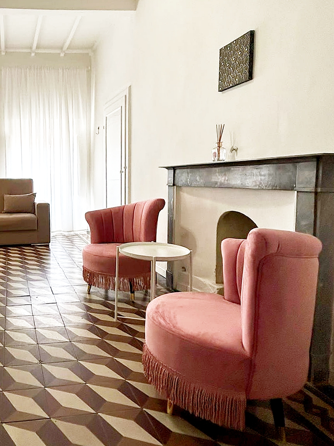 poltrone-e-camino-loft-arezzo Due poltrone rosa accanto al camino storico del loft ad Arezzo