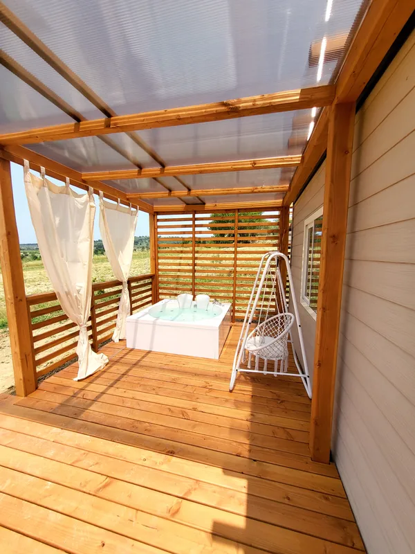 veranda-bungalow-menta-con-jacuzzi Veranda in legno del bungalow Menta con vasca idromassaggio e poltrona sospesa