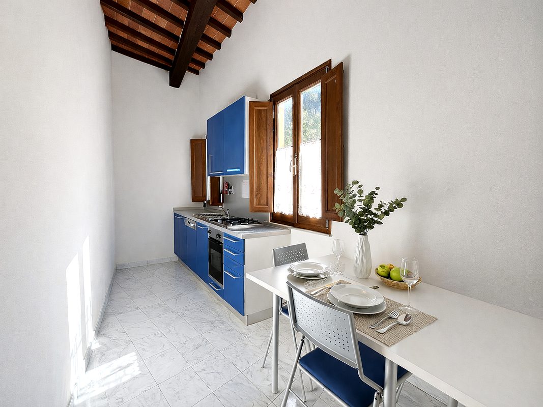 bed-and-breakfast-arezzo-cucina-francesco-petrarca Cucina della camera Francesco Petrarca con mobili blu e tavolo apparecchiato
