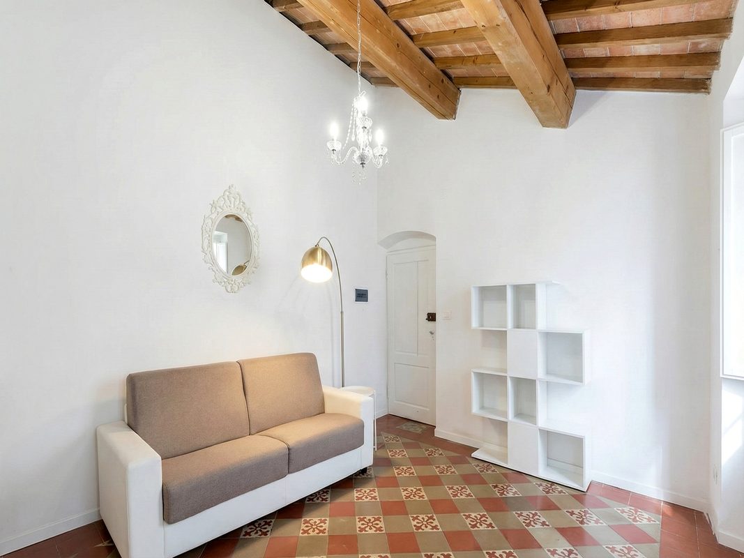 dormire-ad-arezzo-soggiorno-attico-2 Soggiorno dell’Attico 2 ad Arezzo con divano e soffitto con travi in legno
