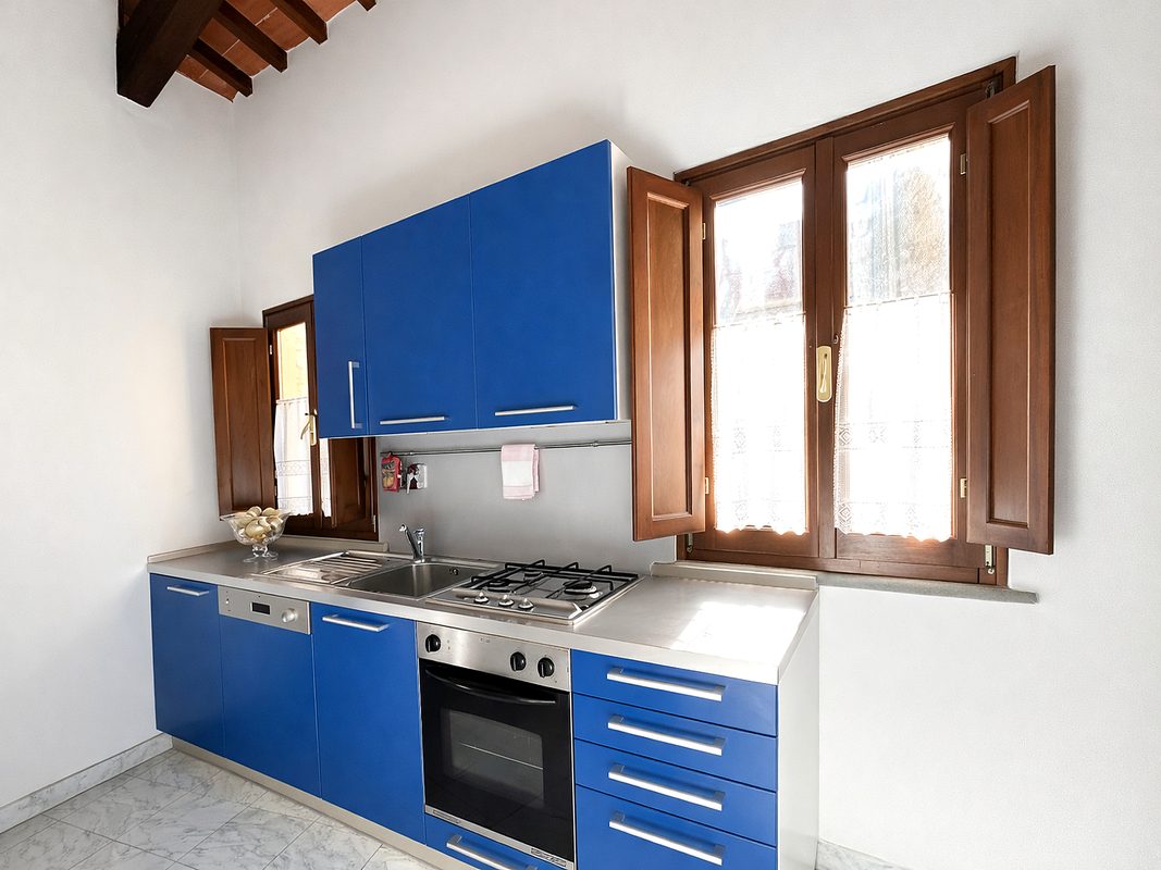 dormire-ad-arezzo-cucina-francesco-petrarca Cucina blu della camera Francesco Petrarca con forno, piano cottura e finestre in legno